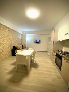 a kitchen and dining room with a white table and chairs at Central Apartments in Crotone