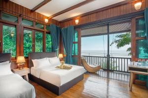 a bedroom with two beds and a balcony at Rawa Island Resort in Mersing