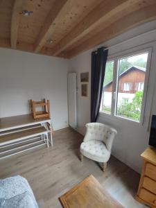 a living room with a white chair and a window at Appartement T3 50m² - 6 pers. - Barcelonnette in Barcelonnette