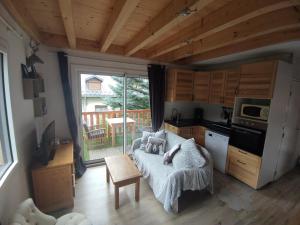 a living room with a couch and a kitchen with a window at Appartement T3 50m² - 6 pers. - Barcelonnette in Barcelonnette