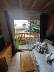 a living room with a couch and a sliding glass door at Appartement T3 50m² - 6 pers. - Barcelonnette in Barcelonnette