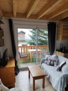 a living room with a couch and a sliding glass door at Appartement T3 50m² - 6 pers. - Barcelonnette in Barcelonnette