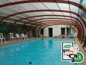 a swimming pool with a roof over it at Garabit Hotel in Garabit