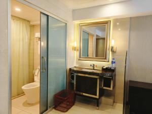 a bathroom with a sink and a toilet and a mirror at Clayton Hotel-Near Pazhou Exhibition Center in Guangzhou