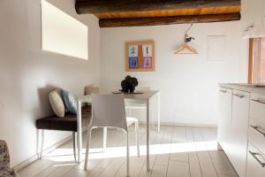 een keuken met een witte tafel en stoelen bij Verzasca Lodge Elma in Sonogno