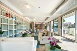 a living room with white furniture and a large window at Junior Family Hotel in Cavallino-Treporti +88 photos