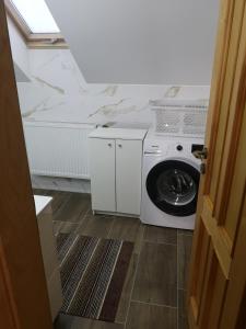 eine weiße Waschmaschine und ein Trockner in einem Zimmer in der Unterkunft Chata Nikol in Oravská Lesná