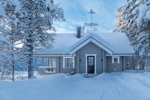 una pequeña casa con nieve en el techo en Villa Äkäsjoensuu, en Äkäslompolo