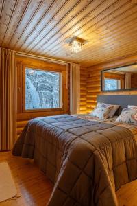 a bedroom with a large bed in a cabin at Villa Äkäsjoensuu in Äkäslompolo