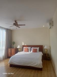 sypialnia z łóżkiem z białą pościelą i różowymi poduszkami w obiekcie Homestay Yellow Natural House w Siem Reap