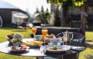 - une table avec des assiettes de nourriture et deux verres de champagne dans l'établissement Hotel Adula, à Flims