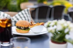 a white plate with a sandwich and a bowl of bacon at Hotel Adula in Flims