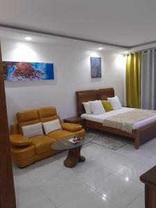 a living room with a bed and a couch at RESIDENCE FABY 1 in Dakar