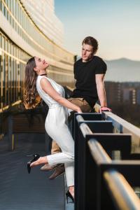 a man and a woman sitting on a railing at CUE Podgorica in Podgorica