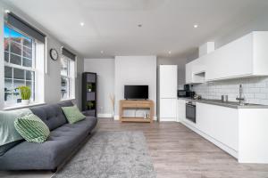 uma sala de estar com um sofá e uma cozinha em Luxury Flat with private terrace in the Heart of Kingston em Londres