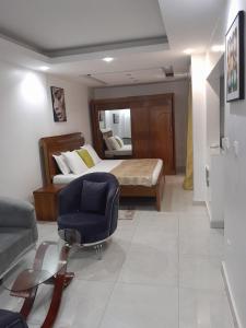 a bedroom with a bed and a chair and a couch at RESIDENCE FABY 1 in Dakar