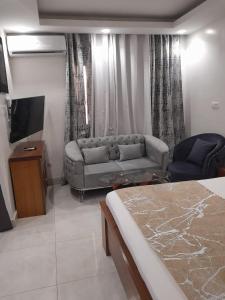 a hotel room with a bed and a couch at RESIDENCE FABY 1 in Dakar