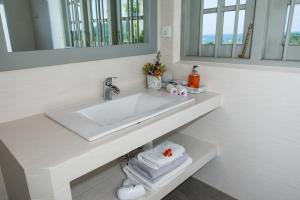 a white bathroom with a sink and a mirror at The Horizon Hill Top Villa in Unawatuna