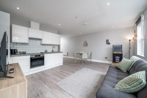 a living room with a couch and a kitchen at Luxury Flat with private terrace in the Heart of Kingston in London