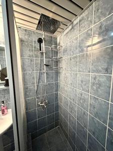 a bathroom with a shower with a tiled shower at Penthouse with unique sea view and private terrace in Konak