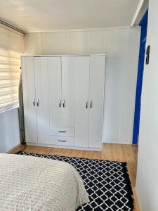 1 dormitorio con armarios blancos y 1 cama con alfombra en Penthouse with unique sea view and private terrace, en Konak