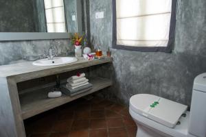 a bathroom with a sink and a toilet and a mirror at The Horizon Hill Top Villa in Unawatuna