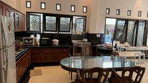 a kitchen with a glass table and a refrigerator at Fora Capsule Hostel Tuban Kuta Bali in Kuta