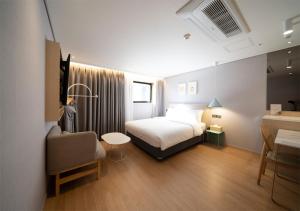 ein Hotelzimmer mit einem Bett und einem Stuhl in der Unterkunft Nampo Ocean2Heaven Hotel& Spa in Busan