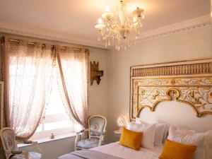 a bedroom with a large bed and a chandelier at Dar Yessine Boutique Hôtel in Sousse
