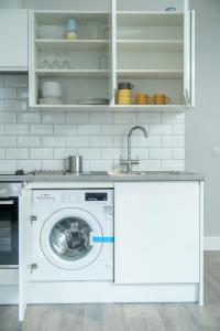 uma cozinha com uma máquina de lavar roupa e um lavatório em Luxury Flat with private terrace in the Heart of Kingston em Londres