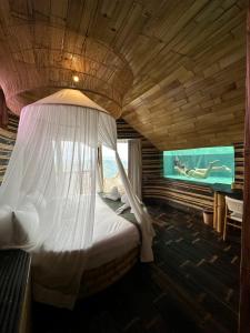 Bungbungan的住宿－Cliffside Bamboo Treehouse with Pool and View，一间卧室配有一张带蚊帐的床