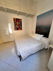 a bedroom with a bed and a painting on the wall at cvr 3- Monolocale luminoso a due passi dalla Torre in Pisa