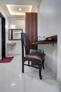 uma cadeira sentada num quarto com um lavatório em StayBird - NEST, A Premium Residences, Kharadi em Pune
