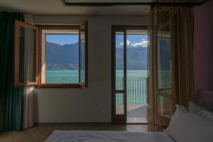 a bedroom with a bed and a view of the water at Hotel all'Azzurro in Limone sul Garda