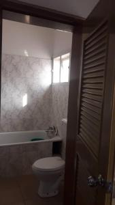 baño con aseo, bañera y ventana en Gifted Apartment & Residence, en Abuja