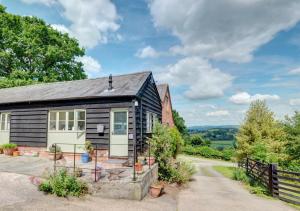 a black and white cottage with a driveway at Pandy Barn in Berriew