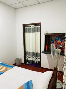 Schlafzimmer mit einem Bett, einem Ventilator und einem Fenster in der Unterkunft JUNGLE VILLA in Galle