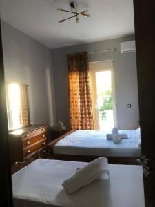 a bedroom with two beds and a window at Villa Castle View in Shkodër