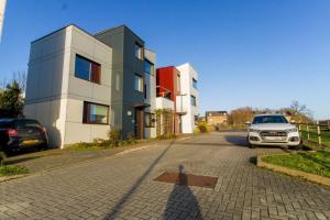 um carro estacionado num parque de estacionamento ao lado de um edifício em 4 Bed MK Cosy & Well equipped House em Shenley Church End