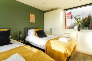 2 łóżka w pokoju z zielonymi ścianami w obiekcie 4 Bed MK Cosy & Well equipped House w mieście Shenley Church End