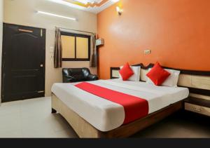 a hotel room with a large bed with red pillows at Hotel sunrise in Lucknow