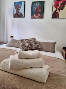 un letto con sopra un mucchio di asciugamani di ALLOGGIO CENTRALISSIMO SANREMO a Sanremo