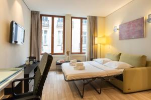 une chambre d'hôtel avec un lit et un canapé dans l'établissement B-aparthotel Grand Place, à Bruxelles