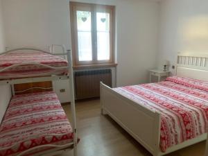 a bedroom with two bunk beds and a window at CASA PIAZZALE ALPINI in Schilpario