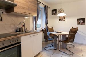 a kitchen with a table and chairs and a sink at NEU! Reiterhof Finkenmühle Fewo Gipsy in Weißenstadt