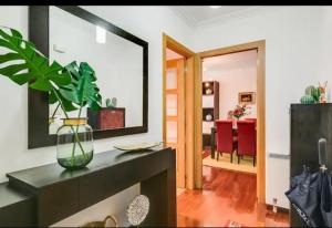 a living room with a mirror and a table with a plant at Alojamiento A Tafona in Caldas de Reis