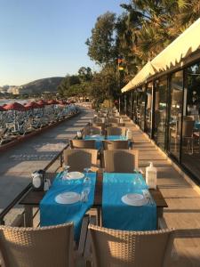 a row of tables and chairs with blue table cloth at Batıhan Beach Resort & Spa in Kusadası