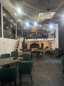a restaurant with tables and chairs and a fireplace at Bella apartman in Mladenovac