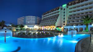 a hotel with a swimming pool at night at Batıhan Beach Resort & Spa in Kuşadası