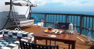 a wooden deck with a table with a glass of wine at Grid 1398 in Namhae
